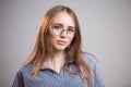 Horizontal portrait of beautiful young woman wearing glasses and shirt on grey background. Student girl looking at camera Royalty Free Stock Photo