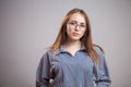 Horizontal portrait of beautiful young woman wearing glasses and shirt on grey background. Student girl Royalty Free Stock Photo