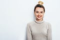 Horizontal portrait of cheerful woman with appealing smile, having hair bun wearing in sweater isolated over white background. Royalty Free Stock Photo