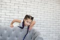 Horizontal portrait of a five year old girl in a white dress playing against a gray brick wall Royalty Free Stock Photo