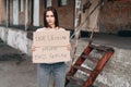 Horizontal Portrait of girl with sad face with cardboard box in her hands, Looks straight ahead