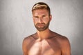 Horizontal portrait of handsome unshaven man with dark eyes, stylish hairdo staanding topless over grey background. Young muscular Royalty Free Stock Photo