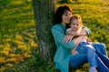 Horizontal portrait of happy mom and daughter having a rest in summer park