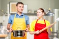 horizontal portrait of a man with a pan and a woman with a rolling pin Royalty Free Stock Photo