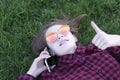 Carefree model in red plaid shirt laying down on fresh green grass