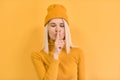 Horizontal portrait of pretty woman pressing finger against her lips, saying Shh, hush, asks to be quiet, wears in yellow clothes Royalty Free Stock Photo