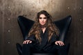 Horizontal portrait of a reputable young woman in the black chair. Royalty Free Stock Photo