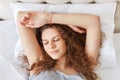 Horizontal portrait of sleepy cute female with curly hair, pleas