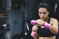 Horizontal portrait of strong young woman doing exercise with dumbbells. Fitness European female doing intense training in the gym Royalty Free Stock Photo