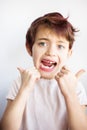Horizontal portrait of 7 years old unhappy child in white t-shirt flossing his teeth on white background isolated. Healthcare and Royalty Free Stock Photo