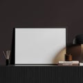 Horizontal poster on wooden dresser in black room