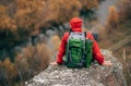 Horizontal rear view image of young handsome hiker man sitting on the rock, relaxing and enjoy the beautiful nature view. Royalty Free Stock Photo