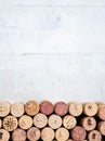 Horizontal row of corks, on a white wooden table with a lot of negative space above. Useful for advertising on wines, wine bars, Royalty Free Stock Photo