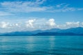 Horizontal of Seascape including Forest Mountain, Blue Sky and Wave of Water. Royalty Free Stock Photo