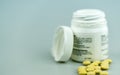 Selective focus close up of white prescription pill bottle and yellow pills Royalty Free Stock Photo