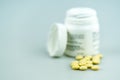 Selective focus close up of white prescription pill bottle and yellow pills Royalty Free Stock Photo