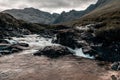 Horizontal shot from above the waterfall in woods under a dark cloudy sky of Ilse of Skye, Scotland Royalty Free Stock Photo