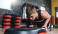 Horizontal shot of athlete man doing on stepper pushups in aerobic fitness club. The handsome male is exercising his chest on the Royalty Free Stock Photo