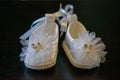 Adorable white baby girl shoes with pearl details and sparkly decorations Royalty Free Stock Photo