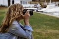Attractive professional female photographer traveling with her DSLR camera taking pictures around the world.