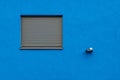 Horizontal shot of a blue wall with a grey window blind - great for a cool wallpaper or background Royalty Free Stock Photo