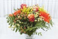 Bouquet of orange, yellow and red flowers in a vase on white background. Royalty Free Stock Photo