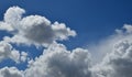 Horizontal shot of a bright blue sky with white puffy clouds. Royalty Free Stock Photo