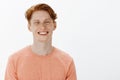 Horizontal shot of charming confident redhead young man with freckles and bright smile, grinning and gazing joyfully at Royalty Free Stock Photo