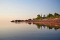 Coast of the Lake Peipus at sunset. Church of the apostles Peter and Paul in Vetvenik, Pskov region. Royalty Free Stock Photo