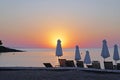 Horizontal shot. Empty beach in the evening at sunset. . Umbrellas Silhouettes and coastline. Royalty Free Stock Photo