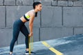 Horizontal shot of the fit woman exercising with resistance band on a sunny day outdoor. Athelte female posing with elastic band