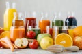 Horizontal shot of fresh fruit and vegetables on white table, glass jars of juice and orange squeezer. Healthy drinks concept. Royalty Free Stock Photo