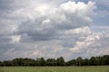 Horizontal shot of green fenced farmland under the cloudy sky