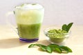 Horizontal shot of Green tea matcha latte with milk foam in a cup with green leaves and powed matcha. Royalty Free Stock Photo