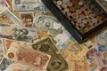 Horizontal shot of a handful of numismatic collection banknotes and a wooden box with coins from various countries of the world in