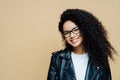 Horizontal shot of happy healthy woman with natural curly hair, pleasant smile, enjoys spare time and doing shopping at weekend, Royalty Free Stock Photo