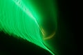 Horizontal shot of intersecting refracted green light layers on a black background