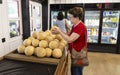 A Woman Shopper Examines Cantaloupe In Store Royalty Free Stock Photo