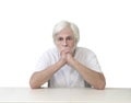 Older Man Sitting At Table With Hands On Chin Royalty Free Stock Photo