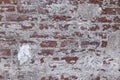 Horizontal shot of a red and white old stone wall with texture and some plaster on it