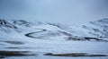 Horizontal shot of S-shaped road surrounded by snow