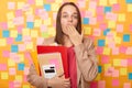 Horizontal shot of shocked astonished woman with brown hair wearing beige jacket, covering mouth with palm, forget something Royalty Free Stock Photo