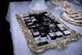Horizontal shot of small pieces of browny covered with powdered sugar set on a oldfashioned tray