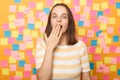 Horizontal shot of surprised Caucasian woman wearing striped t shirt, sees something astonishing, saying wow, covering mouth with Royalty Free Stock Photo