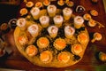 Horizontal shot of sweet buffet snacks on a round wooden board set on a table next to other candies Royalty Free Stock Photo