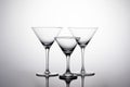 Horizontal shot of three cocktail glasses on the white surface with shadows