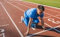 Horizontal shot of young athlete male at starting position ready to start a race. Man sprinter ready for sports exercise on Royalty Free Stock Photo