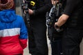 Horizontal shot of young boy looking at armed police within the crowd