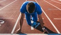 Horizontal shot of young male athlete at starting block on running track. Caucasian sprinter man in starting position for running Royalty Free Stock Photo