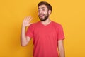 Horizontal shotof excited young man dresses red casual t shirt, spreading hand and keeping mouth wide open, looking surprised, Royalty Free Stock Photo